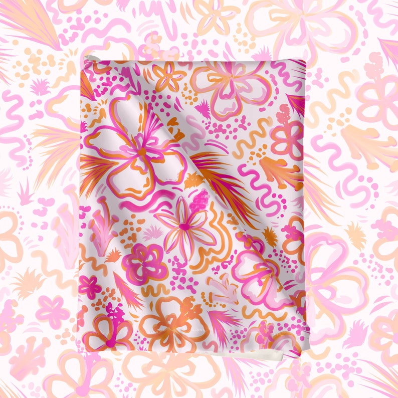 May include: A white fabric with a pink and orange floral pattern. The fabric is folded in half and the pattern is visible on both sides.