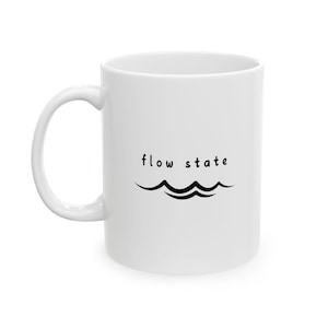 May include: White ceramic mug with a black graphic of two wavy lines and the text "flow state".