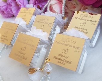 May include: Gold boxes with white pearl prayer beads inside. The boxes have Arabic text and the words "And we created you in pairs (78:8)" and "Nikkah of Shamoon & Farah 26.09.2021".