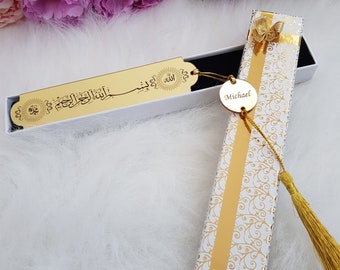 May include: A gold bookmark with Arabic calligraphy and a gold tassel in a white box with a gold ribbon. The box also includes a gold circle with the name "Michael" engraved on it.