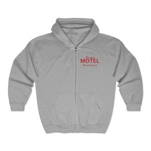 May include: A gray zip-up hoodie with a red embroidered logo that says "Rosebud Motel Housekeeping".