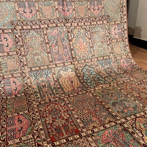 May include: An intricately designed rug with a repeating pattern of stylized trees and floral motifs in shades of pink, green, and brown. The rug has a detailed border and a traditional aesthetic.