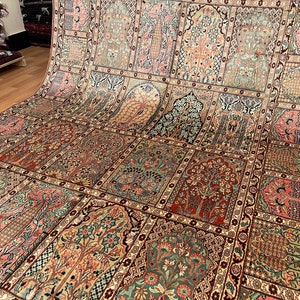 May include: An intricately designed rug with a repeating pattern of arched panels, each featuring floral and tree motifs in shades of red, pink, green, and beige. The rug has a detailed border and a warm color palette, suggesting a traditional or oriental style.