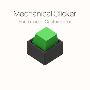 May include: A mechanical clicker with a bright green square button set in a black rectangular base. The text "Mechanical Clicker" and "Hand made - Custom color" are displayed above the clicker.