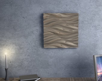 Può includere: Un'opera d'arte da parete quadrata in legno con un motivo a onde nei toni del marrone e del beige. L'opera è montata su un muro grigio. Una candela accesa in un portacandele nero e un'immagine incorniciata sono su un tavolo di legno.