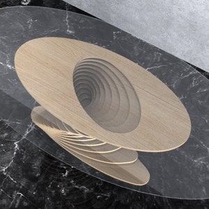 May include: A wooden coffee table with a unique spiral design. The table top is oval shaped and has a clear glass top. The table is on a black marble surface.