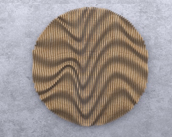 Puede incluir: Una decoración de pared circular hecha de madera con un patrón ondulado. La madera es de color marrón claro.