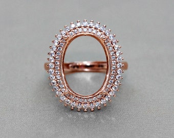 May include: A rose gold ring setting with a large oval shaped center stone opening. The ring is adorned with a double row of small clear cubic zirconia stones around the oval opening.