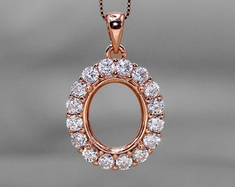 Könnte beinhalten: Ein Anhänger aus Roségold mit einer runden ovalen Form, umgeben von einem Heiligenschein aus kleinen funkelnden Diamanten.
