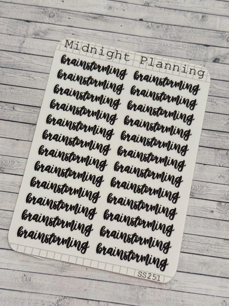 Pu&ograve; includere: Un foglio di adesivi trasparenti con la parola "brainstorming" scritta in lettere corsive nere. Il foglio ha le parole "Midnight Planning" e "SS251" stampate su di esso.