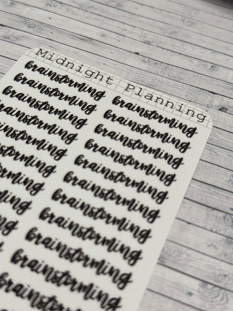 Pu&ograve; includere: Un foglio di adesivi con le parole "Midnight Planning" in alto. Il foglio &egrave; pieno della parola "brainstorming" ripetuta pi&ugrave; volte in un font scritto a mano.