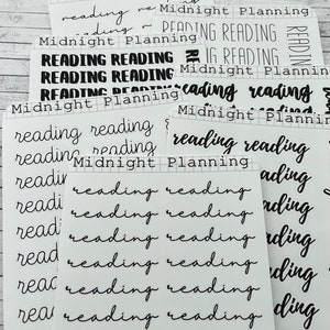 Peut inclure: Une feuille d'autocollants pour planificateur avec les mots "Midnight Planning" et "Reading" répétés dans différentes polices et tailles. Les autocollants sont imprimés sur du papier blanc transparent.