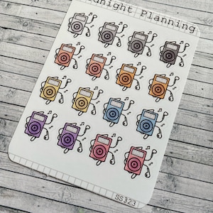 Könnte beinhalten: Eine Bogen mit Aufklebern mit 12 bunten Cartoon-Illustrationen von iPods mit Kopfhörern. Jeder iPod hat eine andere Farbe, darunter Pink, Blau, Lila, Gelb, Orange und Grün. Der Text "Midnight Planning" befindet sich oben auf dem Bogen, und "SS323" unten.