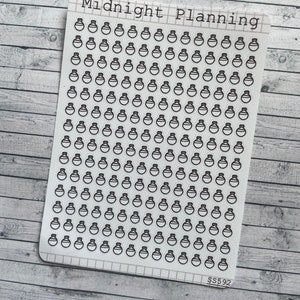 Könnte beinhalten: Ein Blatt weißes Aufkleberpapier mit einem Rastermuster und dem Text "Midnight Planning" oben. Das Blatt ist mit 100 kleinen schwarzen und weißen Aufklebern einer Zaubertrankflasche gefüllt.