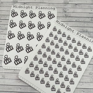 Pode incluir: Duas folhas de papel adesivo branco com imagens de clipes de pasta em contorno preto. A folha superior tem o texto "Midnight Planning" e a folha inferior tem o texto "Midnight Planning" e "SS436".