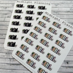 May include: Two sheets of stickers with a bookshelf and a potted plant design. The stickers are white with black text that reads "Midnight Planning". The stickers are on a wood background.