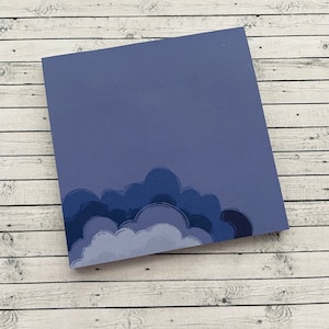 May include: A purple sticky note with a design of blue and white clouds at the bottom.