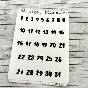 Op de afbeelding: Witte sticker sheet met zwarte nummers 1 tot en met 31 voor gebruik in een planner of dagboek. De tekst "Midnight Planning" staat bovenaan de sheet.