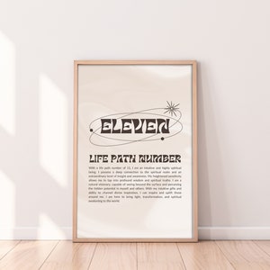 May include: A beige poster with a black and white graphic of the number eleven in a retro font. The poster has the text "Life Path Number" and a description of the meaning of the number eleven in numerology.