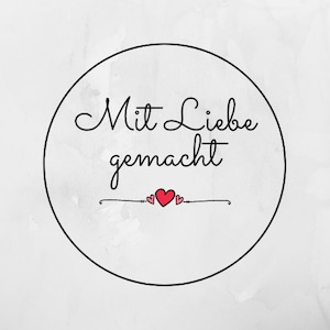 May include: A black and white circle with the text "Mit Liebe gemacht" in cursive script. Two small red hearts are above the text.