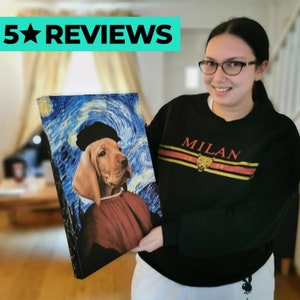 Op de afbeelding: Een canvas print met een hond in een schilder stijl die doet denken aan Vincent van Gogh's "Sterrennacht". De hond draagt een zwarte baret en een roodbruine robe. De print wordt vastgehouden door een persoon die een zwart sweatshirt draagt met het woord "MILAN" erop gedrukt.