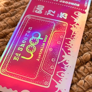 May include: A pink and iridescent concert ticket for the Ed Sheeran Loop Australia tour. The ticket includes details such as the date, time, venue, section, row, and seat number. The ticket has a holographic effect.