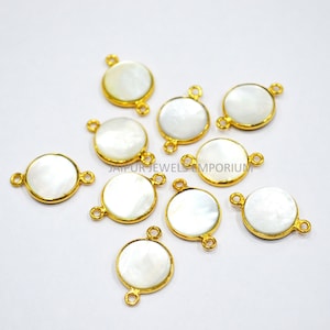 Puede incluir: Diez abalorios redondos de madreperla blanca con detalles en metal dorado. Cada abalorio tiene dos anillos de salto para sujetar a las joyas.