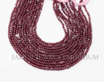 May include: A strand of deep red garnet beads, faceted and polished, arranged in a circular pattern. The beads are small and uniform in size, creating a delicate and elegant look.  The strand is approximately 16 inches long.