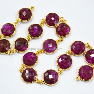 Puede incluir: Una hebra de cuentas de rubí redondas y facetadas con conectores de metal dorado. Las cuentas son de un color rosa intenso y rico y tienen una forma ligeramente irregular. Los conectores son pequeños y delicados, y están espaciados uniformemente a lo largo de la hebra.