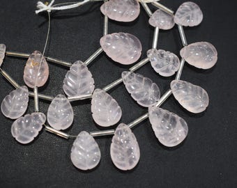 May include: A collection of pale pink rose quartz beads, each carved in a leaf shape. The beads are strung together with silver-colored wire, creating a delicate and natural aesthetic. Ideal for jewelry making.