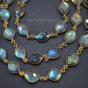 May include: A gold chain necklace with faceted labradorite gemstone beads. The beads are a mix of blue, green, and gold colors. The chain is made of brass.