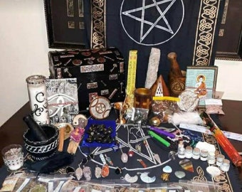 May include: A black velvet altar cloth with a pentagram design. The altar is decorated with various items, including candles, crystals, herbs, and a wooden box. There are also several small bags of herbs and spices.