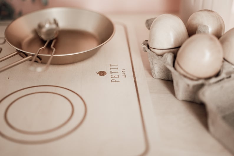 Puede incluir: Un juego de cocina de madera para ni&ntilde;os con una sart&eacute;n dorada y una esp&aacute;tula. El juego tambi&eacute;n incluye una caja de huevos de madera.