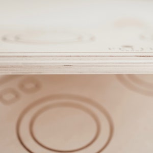 Puede incluir: Un juego de madera con forma de lavadora con un acabado pintado de blanco. El juego tiene un dial redondo con el texto "PLAYTIME" impreso en &eacute;l.