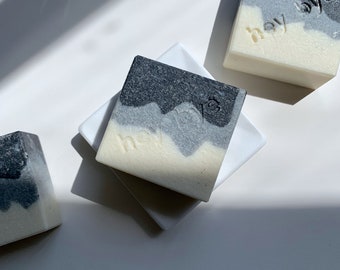 May include: Three bars of soap with a black and gray swirl design. The soap is labeled "hey" on each bar.