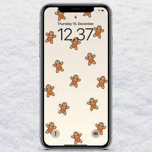 Könnte beinhalten: Ein weißes iPhone mit einem Lebkuchenmann-Hintergrundbild. Die Uhrzeit ist 12:37 Uhr und das Datum ist Donnerstag, der 15. Dezember.