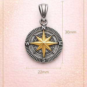 May include: Silver-tone compass pendant with a gold-colored, eight-pointed star in the center. The pendant is 30mm long and 22mm wide. The compass design includes the cardinal directions and is suspended from a silver bail.