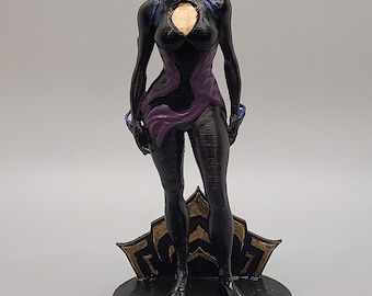 May include: A black and purple figurine of a female character with a helmet and armor. The figurine has a gold accent on the chest and head. The base of the figurine has the text "Kittensaysrawr".