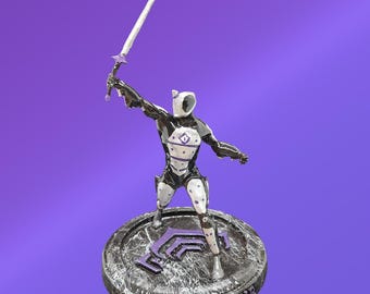 May include: A painted figurine of a humanoid character in a black and white suit, holding a long sword aloft. The figure stands on a circular, textured gray base with a purple emblem and the word EXCALIBUR embossed on the front edge.