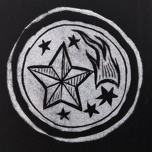 May include: A white and black graphic design featuring a central star with radiating lines, surrounded by smaller stars and a flame-like element. The design is set within a circular border on a black background.