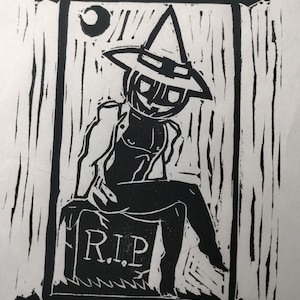 Pode incluir: Impressão em linóleo preto e branco de uma figura usando um chapéu de bruxa e sentada em uma lápide com a inscrição "R.I.P."