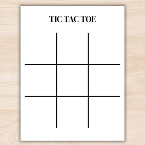 May include: A white sheet of paper with the words "TIC TAC TOE" in a simple, sans-serif font at the top. Below the text is a grid of intersecting black lines, forming the classic tic-tac-toe board.