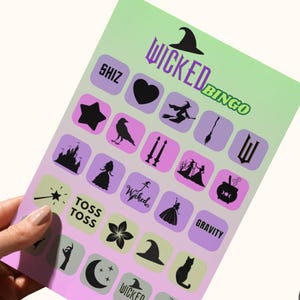Könnte beinhalten: Eine lila und grüne Bingokarte mit dem Titel "Wicked Bingo" und verschiedenen Hexen-Motiven, darunter eine Hexe, ein Kessel, ein Besen und ein Stern. Die Karte ist auf weißem Hintergrund gedruckt.