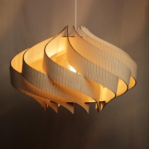 May include: A wooden pendant light fixture with a swirling, layered design. The light is on and illuminates the wood grain.