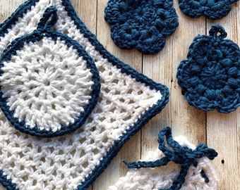 May include: Set of five crocheted kitchen scrubbers in white and blue. The set includes a large square scrubber, a round scrubber, and three smaller round scrubbers.