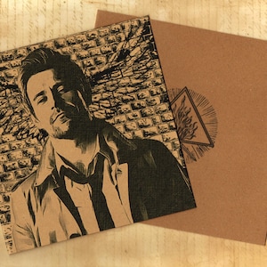 May include: A square brown card featuring a black ink illustration of a man with wings against a brick wall background. A second brown card shows a black ink triangle symbol with flames inside. Both cards have a textured, paper-like appearance.