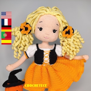 Könnte beinhalten: Eine gehäkelte Halloween-Puppe mit gelben Haaren, einem schwarz-weißen Kleid und einem orangefarbenen Rock. Die Puppe hält einen gehäkelten Kürbis mit einem schwarzen Hut.