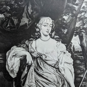 May include: A black and white portrait of a woman wearing a white and red dress with a pearl necklace. She is standing in a forest setting with trees and foliage in the background.