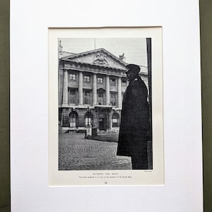 以下が含まれることがあります： 柱のある建物と制服を着た人物の白黒プリント。テキスト「OUTSIDE THE MINT」が下部に印刷され、追加の説明テキストも表示されています。