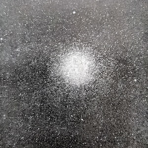 May include: A black background with a white spray paint design. The design is a cluster of white dots that are concentrated in the center of the image and spread out towards the edges.